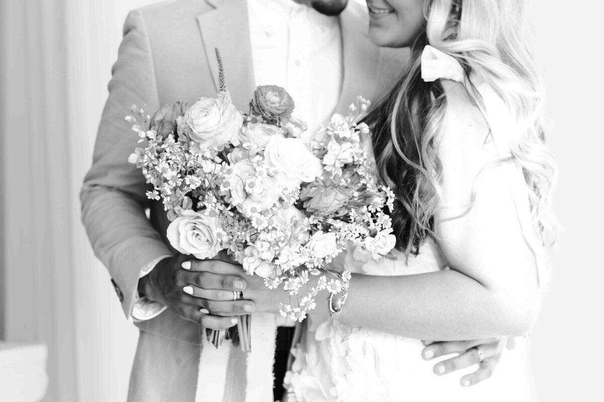 close up of bride and groom holding bouquet in black and white