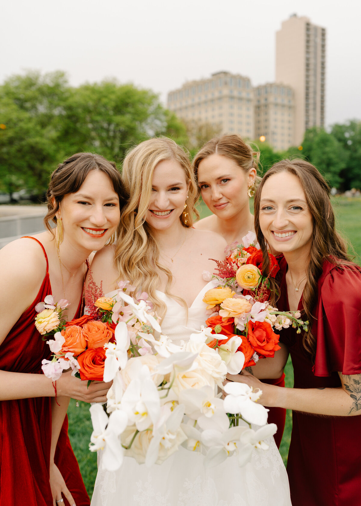 bridesmaids photo inspo red and orange dresses and flowers