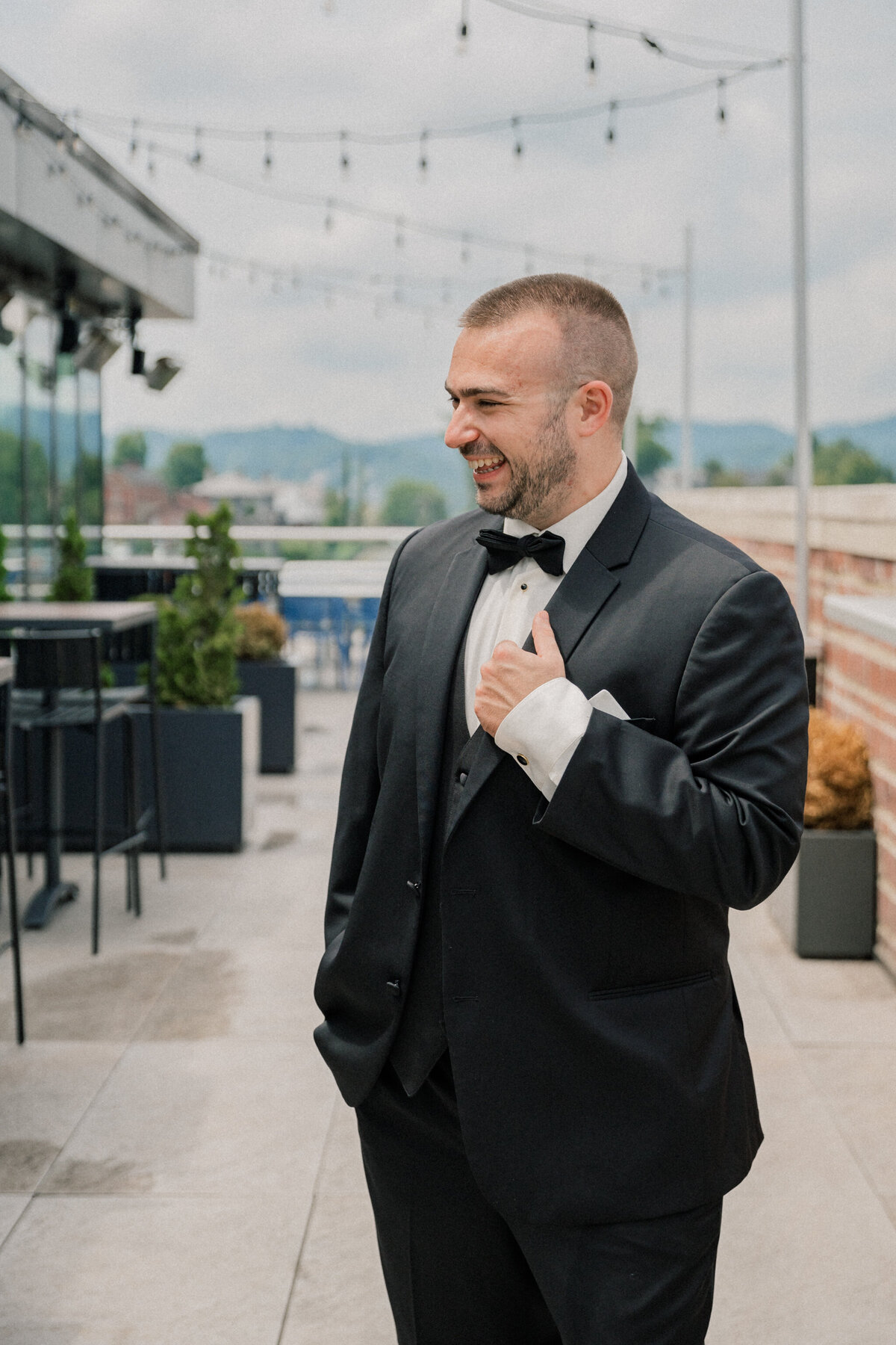 Groom laughing on the rooftop of the Bristol Hotel before his Bristol Train Station wedding