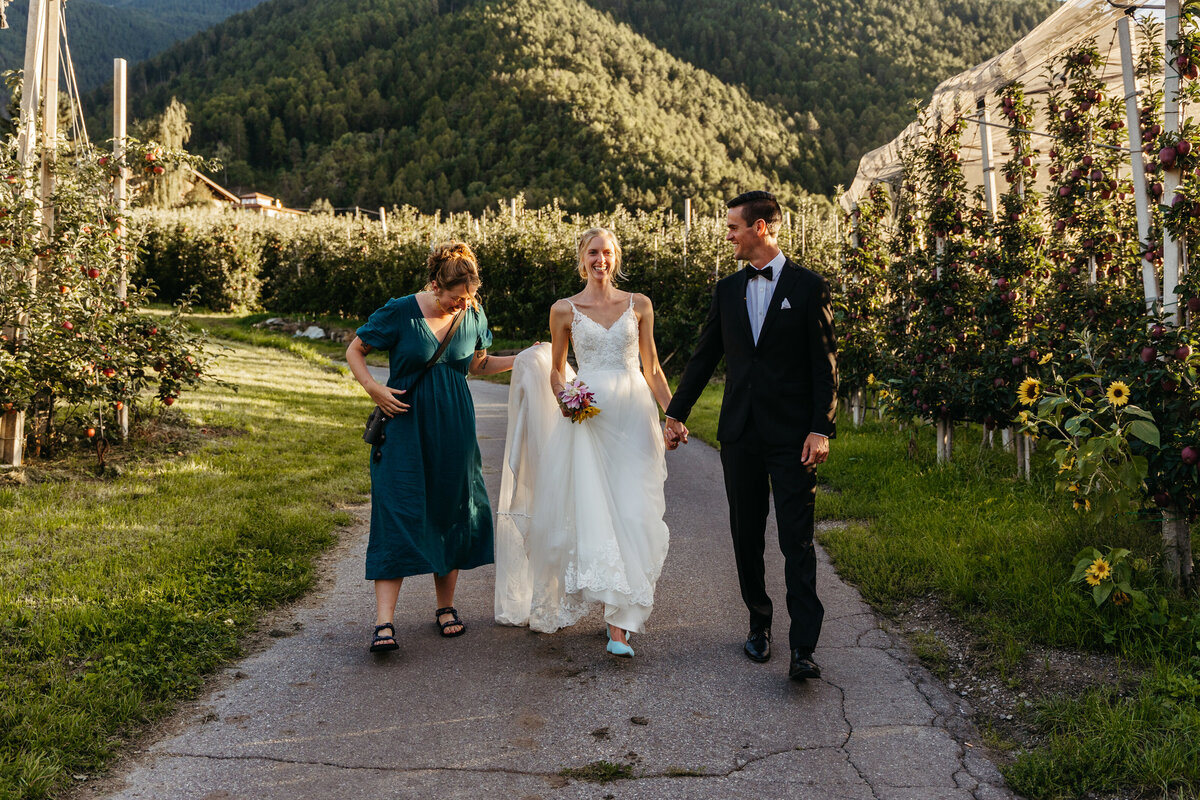 Bride surrounded by friends adjusting her dress