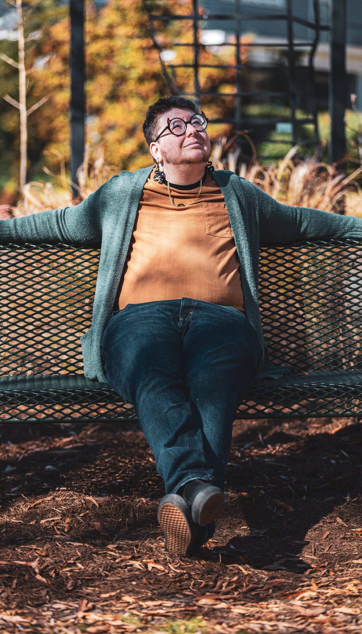 A person sitting on a bench spreading their arms.