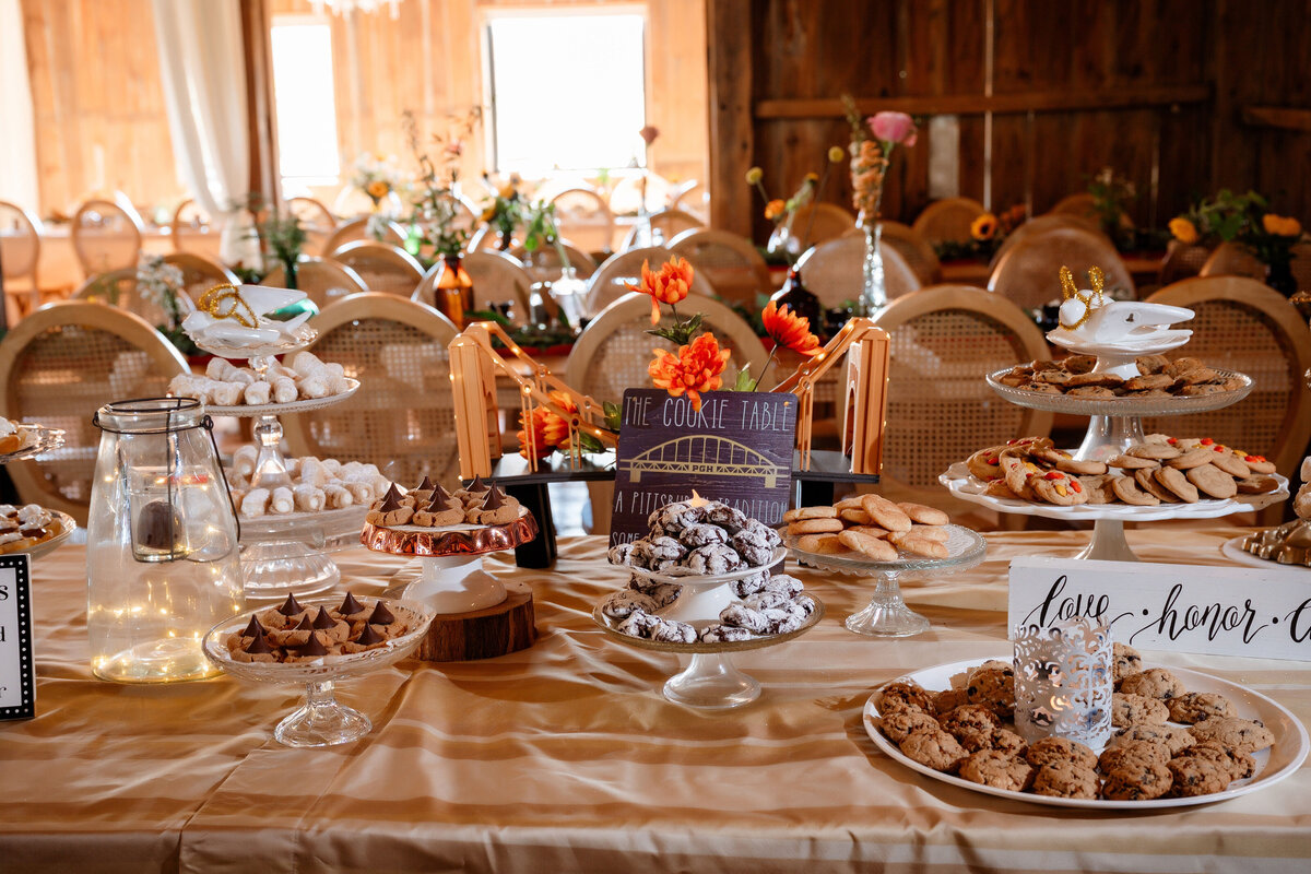 cookie table setup for wedding inside of the barn at shady elms farm on various small plates and trays