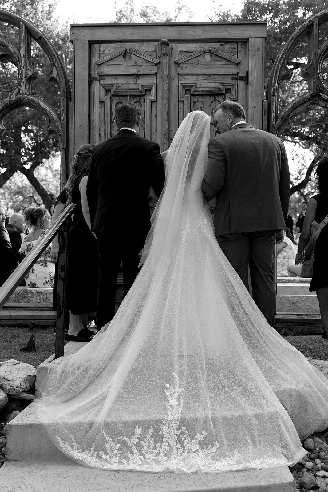 A bride about to walk down the isle with her father and step-father. 