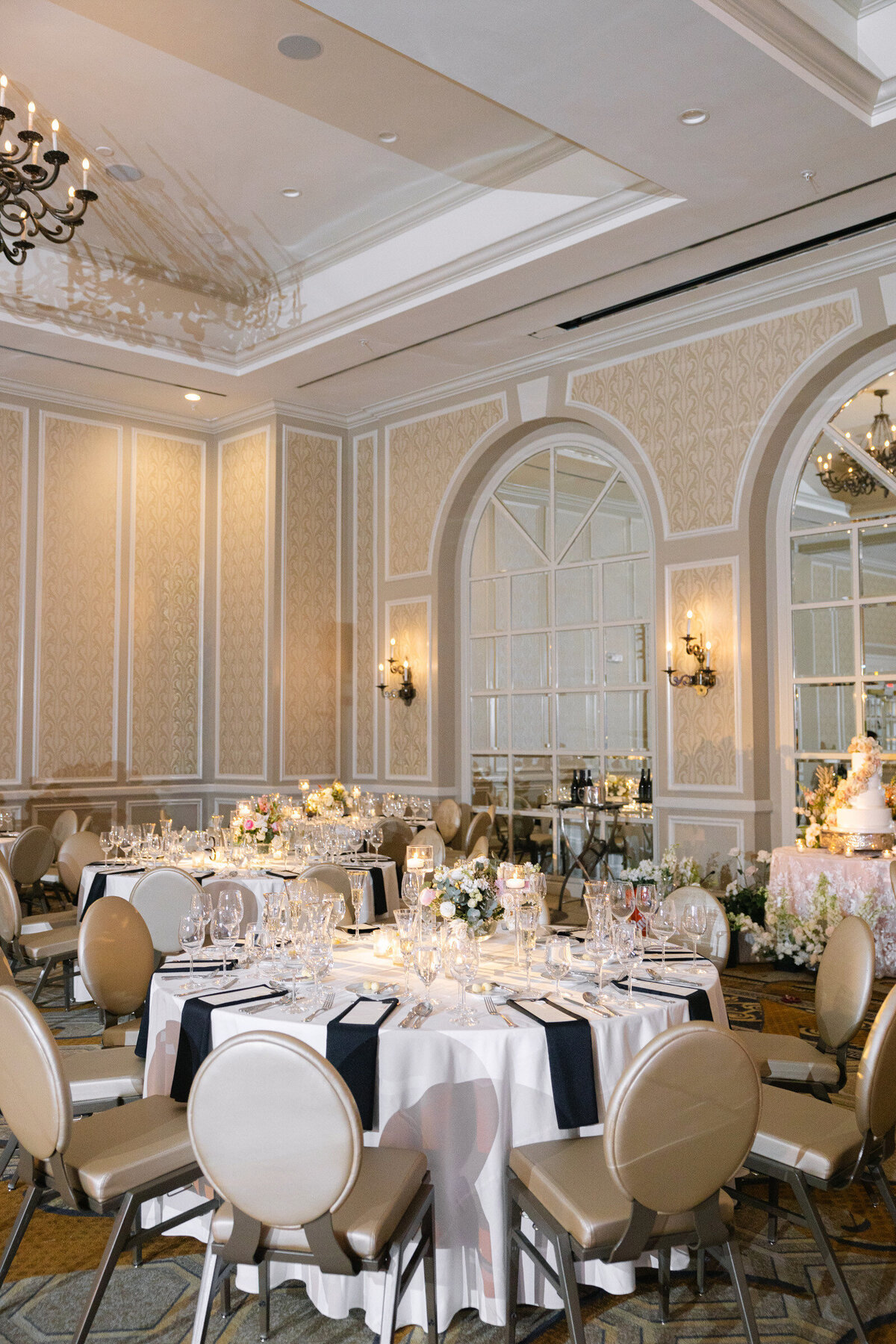 wide-angle view of the wedding reception at The Adolphus in Dallas, featuring elegantly decorated tables with floral centerpieces and candlelight.