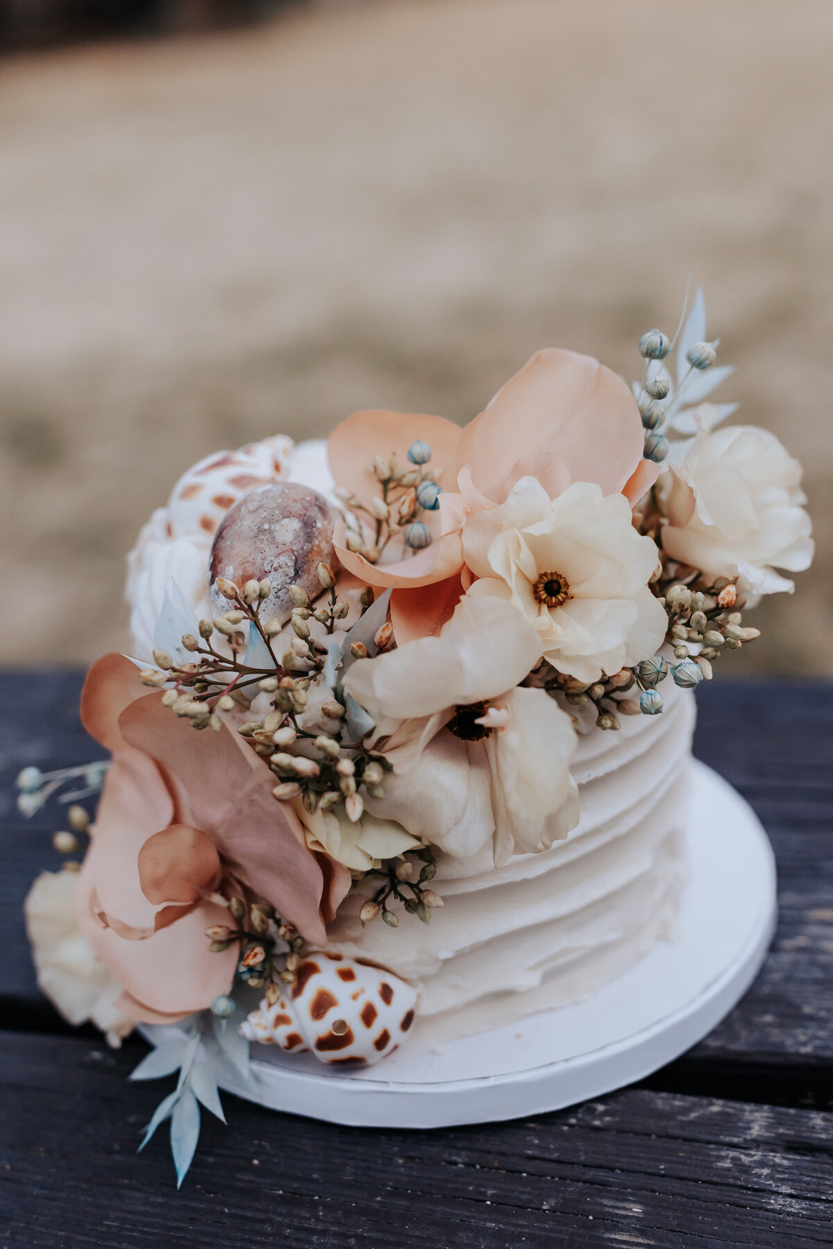 Destination elopement photographer captures wedding cake with florals