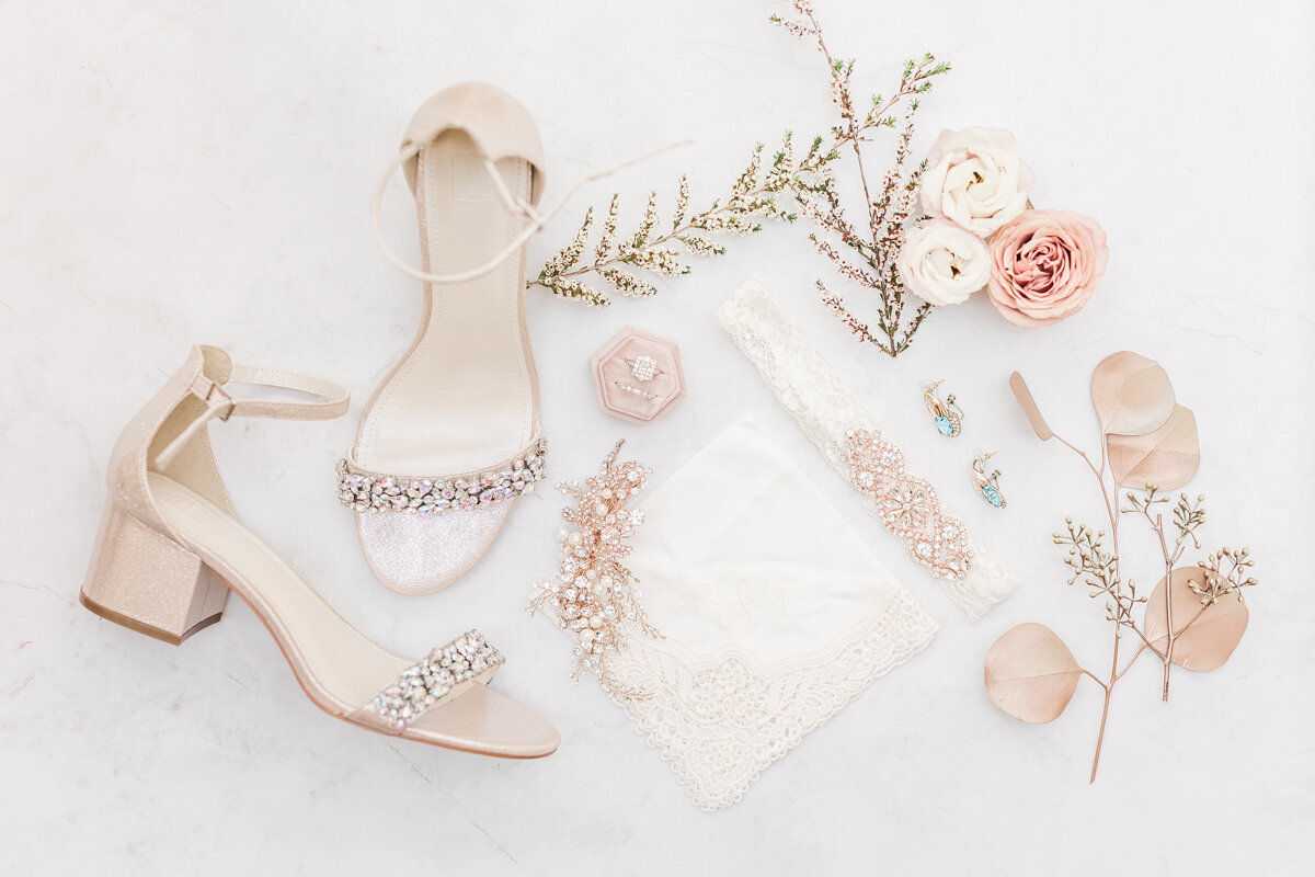 Flat lay of bridal details that are rose gold and pink