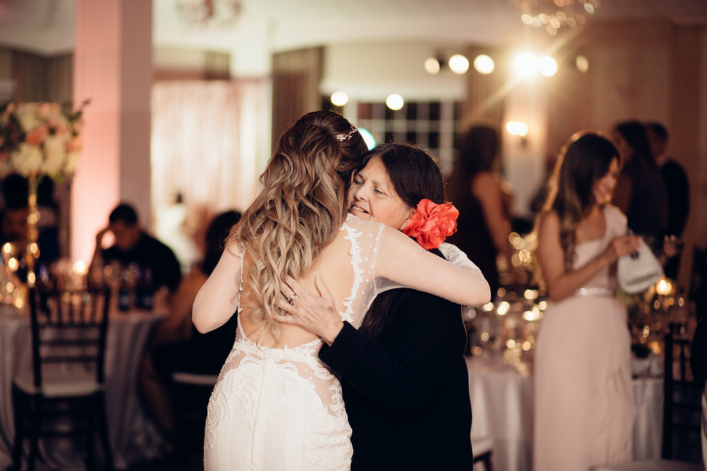 Wedding Photograph Of Bride Hugging a Woman In Black Dress Los Angeles