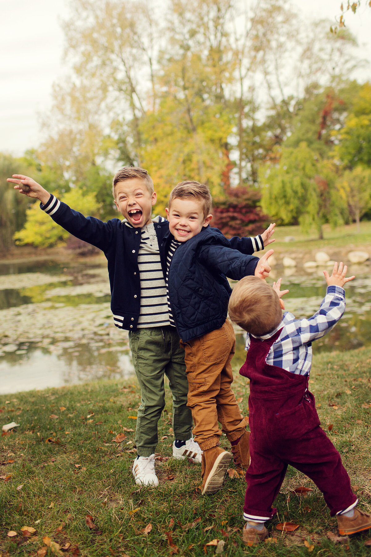 Rambunctious brothers are dancing and laughing at a mini session in the fall.