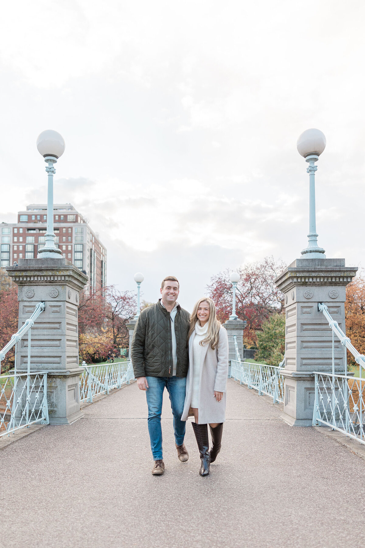 A chic couple strolls on the bridge of the Boston Public Gardens during their engagement session