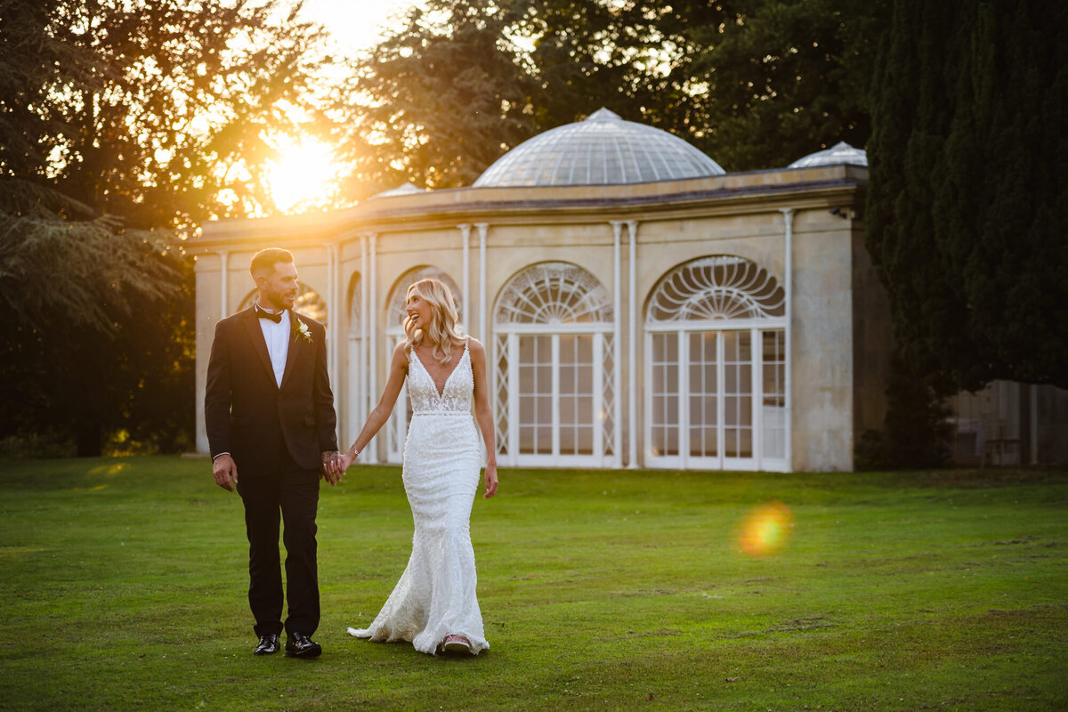 Bride and groom walking through grounds at sunset at barton hall by Amanda Forman Photography