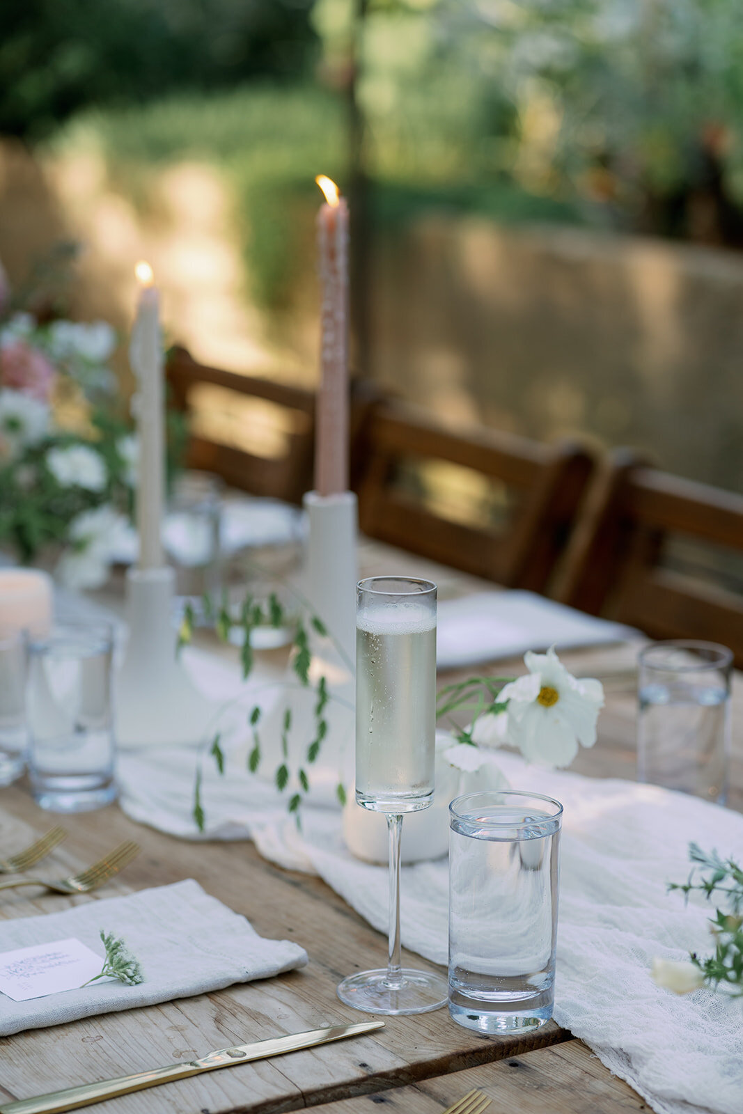 Wedding champagne glasses and décor at the reception table inside Glasshouse Community greenhouse in Ottawa County.