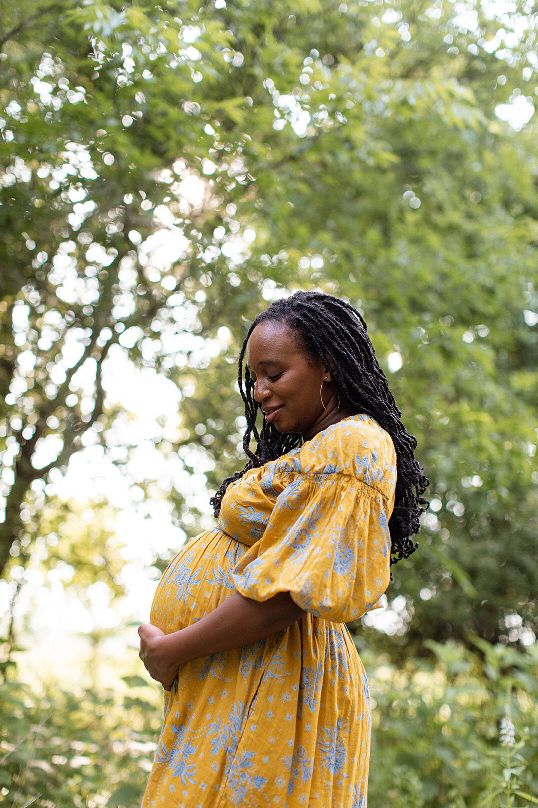 Maternity portrait of a Black pregnant woman standing in a field, photographed by San Antonio family photographer Sara James.