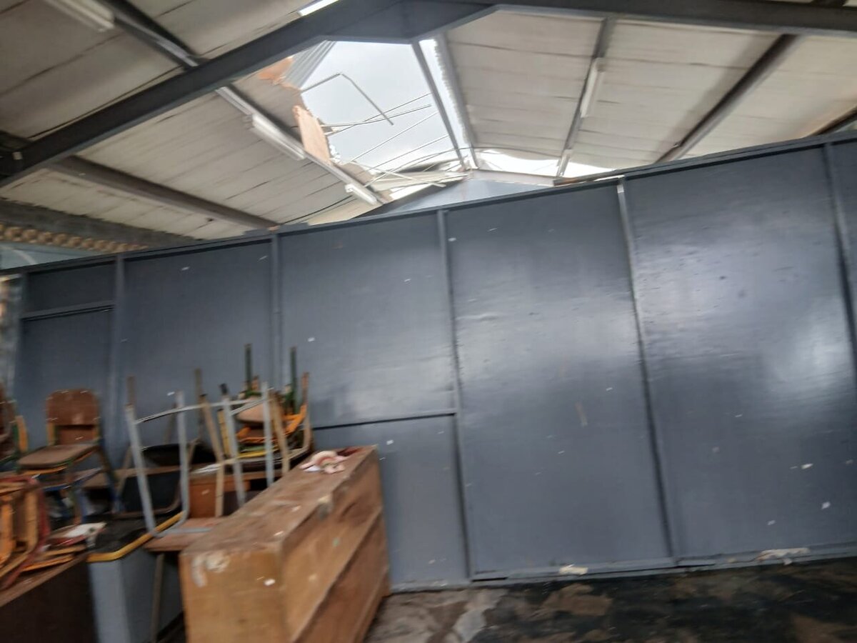 Storage area with roof damage and exposed rafters after the storm.