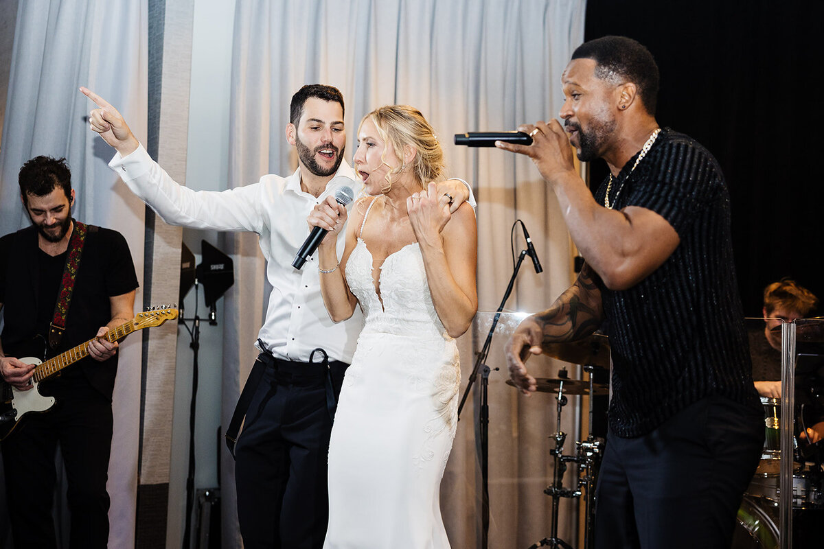 Bride and groom rap on stage at their wedding reception.