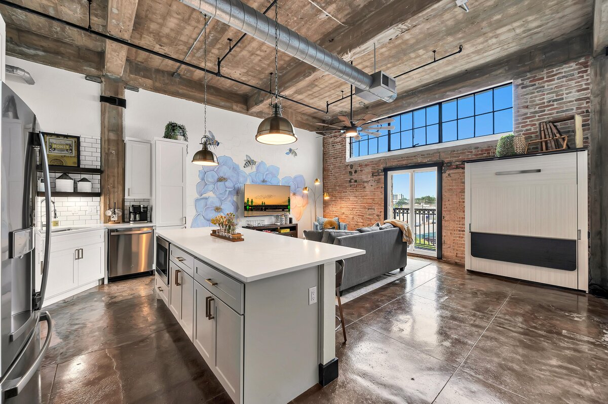 Open concept kitchen, dining, living area with Murphy bed in this one-bedroom, one-bathroom vintage condo that sleeps 4 in the historic Behrens building in the heart of the Magnolia Silo District in downtown Waco, TX.