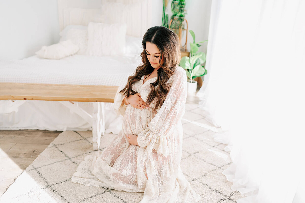 Springfield MO maternity photographer Jessica Kennedy of The Xo Photography captures pregnant mom kneeling on floor in lace dress