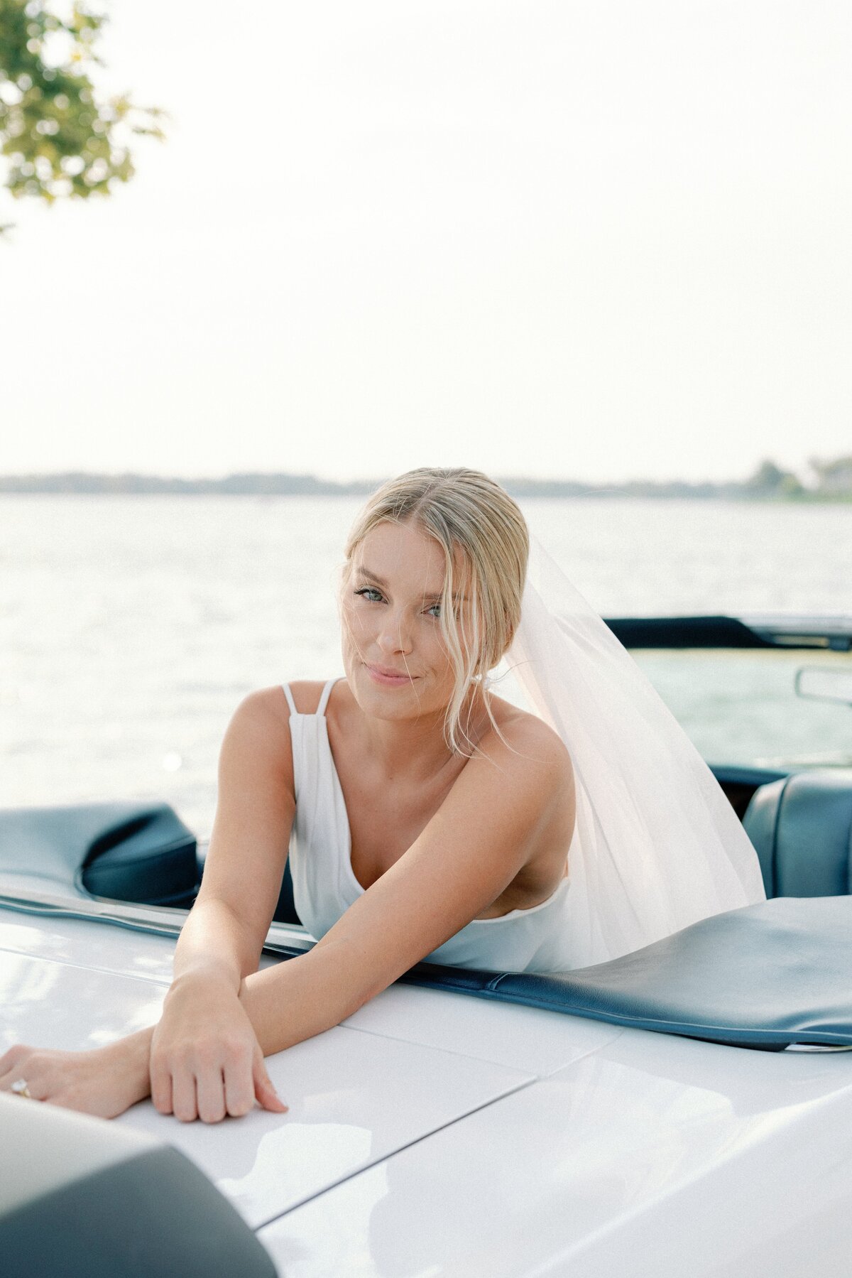 A bride leans over the back of her vintage convertible mustang for editorial bridal portrait by Springfield Illinois wedding photography Lacey Graham 