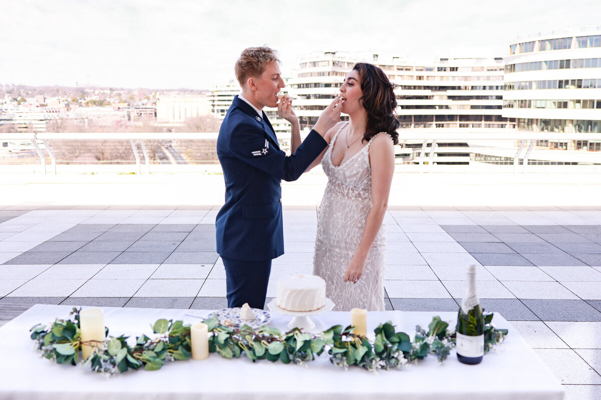 brides feeding each other cake to celebrate their elopement at The Kennedy Center by Washington DC elopement photographer Amanda Richardson Photography