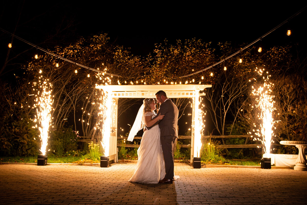 a dramatic display of fireworks goes off in the background as an Ottawa bride and groom have their first dance.  Captured by Ottawa wedding photographer JEMMAN Photography