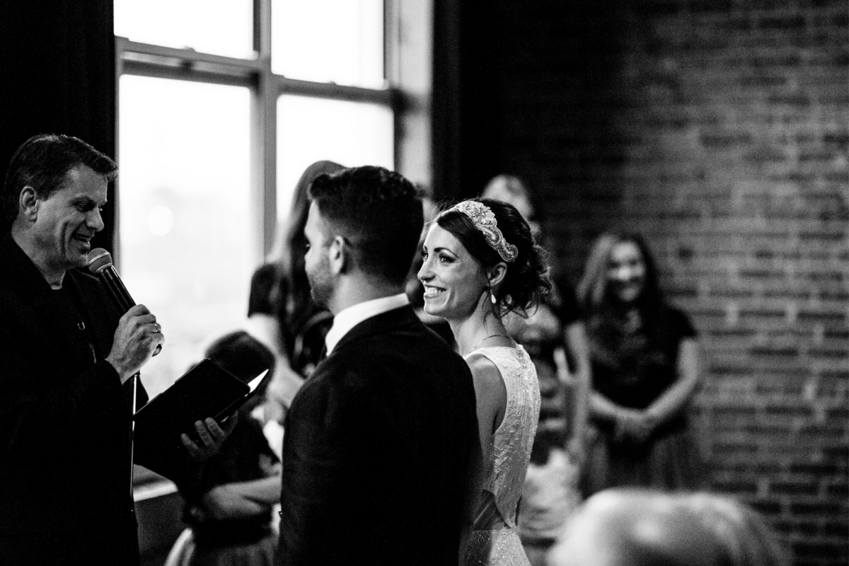 Bride smiles and looks over at her groom during their wedding ceremony
