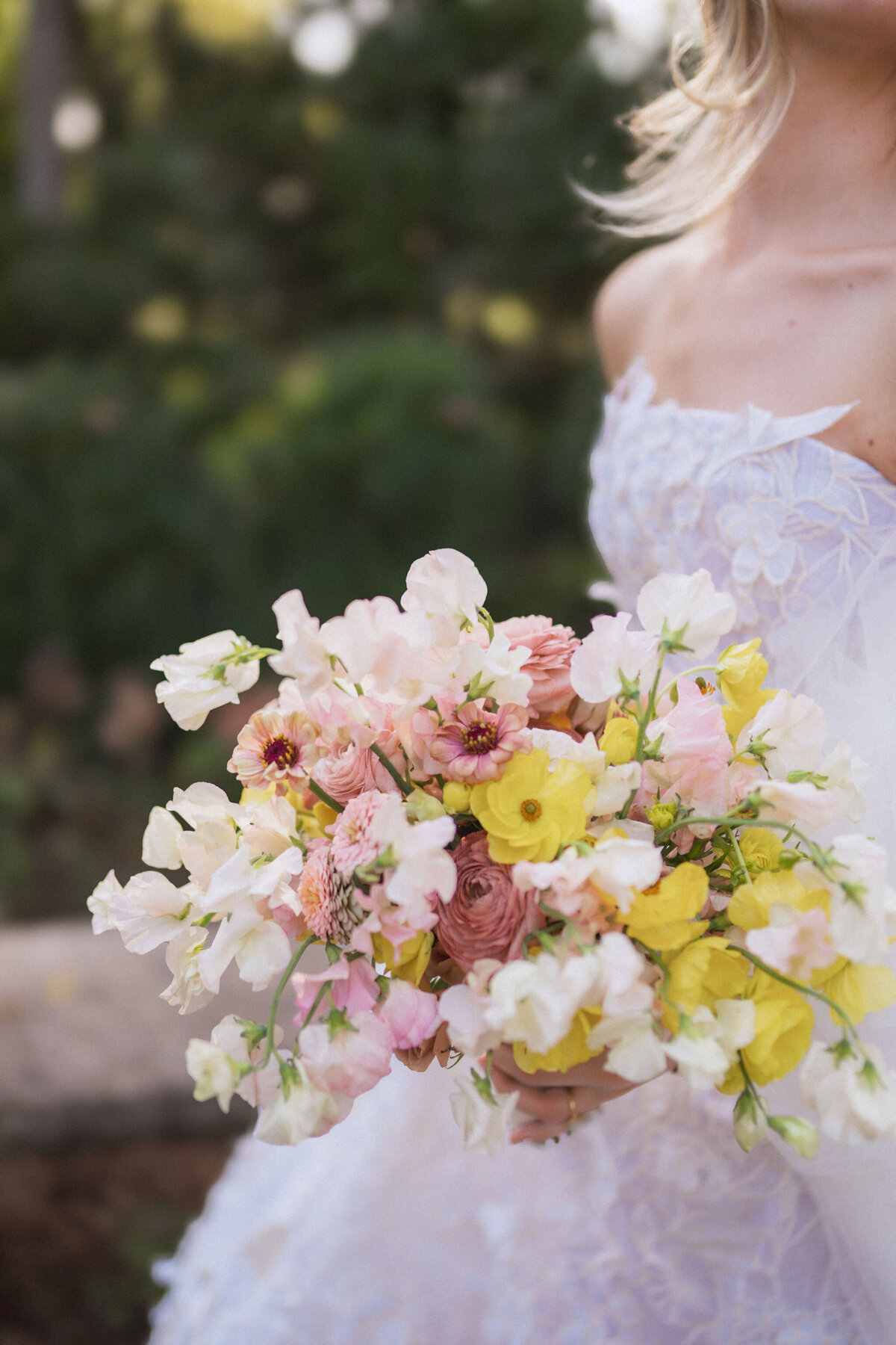 Product clustered bridal bouquet with sweet peas, local zinnias, and butterfly ranunculus. Elegant and simple bridal bouquet and bridal party bouquets with hues of blush and pops of yellow. Unique fall wedding design for private residence wedding in Nashville, TN. Bridal party wearing brown and wedding design with touches of brown. Design by Rosemary & Finch Floral Design in Nashville, TN.