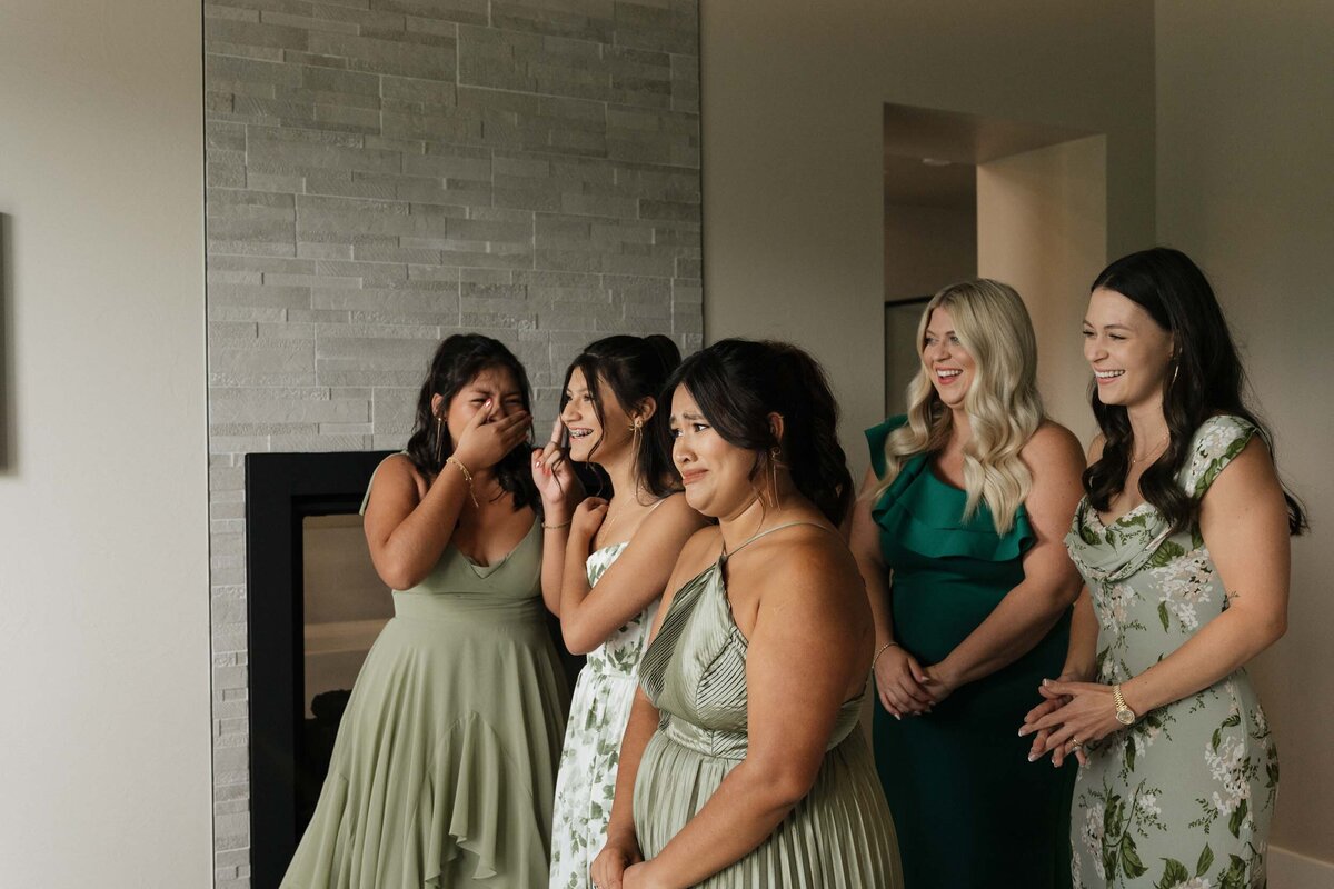 Bridal party and siblings crying after seeing the bride in her wedding dress