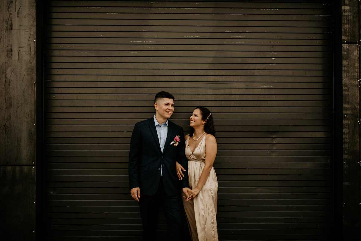 bride and groom standing in front of a black door in downtown Albuquerque