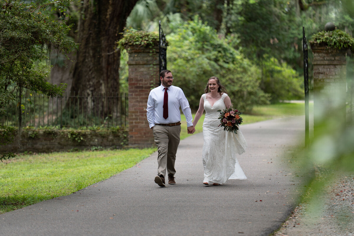 A newlywed couple holding hands and walking together 