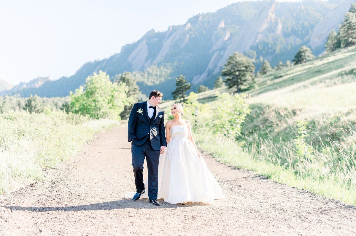 bride and groom holding hands walking away at chautauqua park in boulder colorado