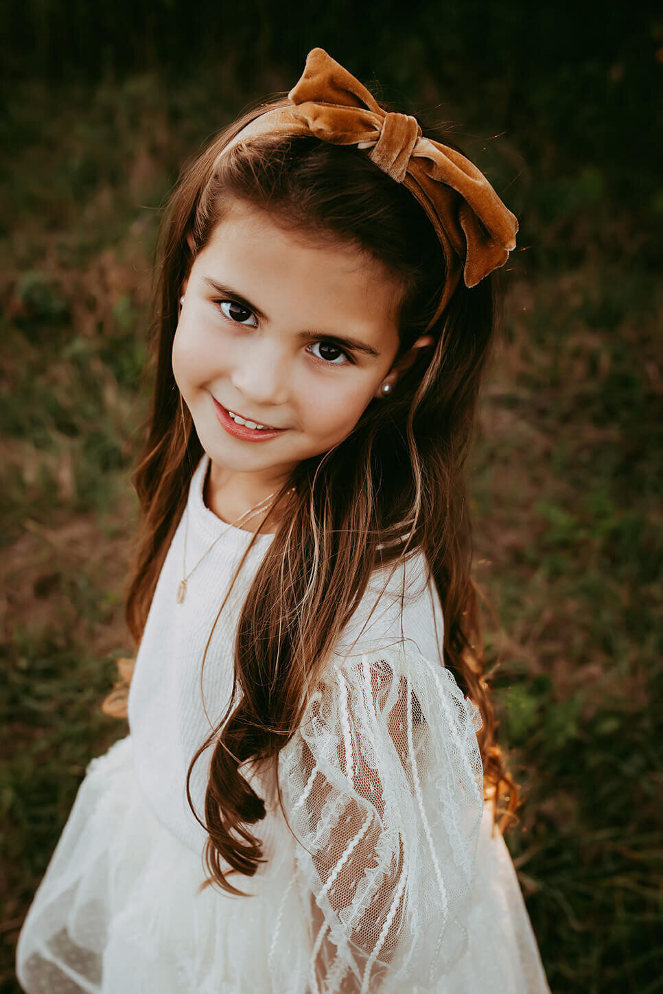 a gorgeous headshot of a six year old girl in a beautiful field in rochester, ny at sunset