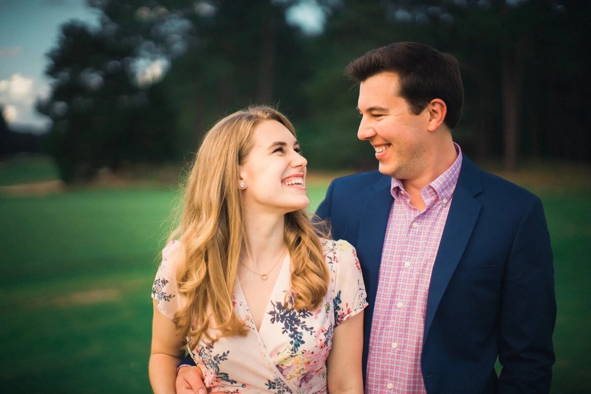 A couple shares a cheerful moment, their affectionate expressions illuminated in the warm, golden hour light.