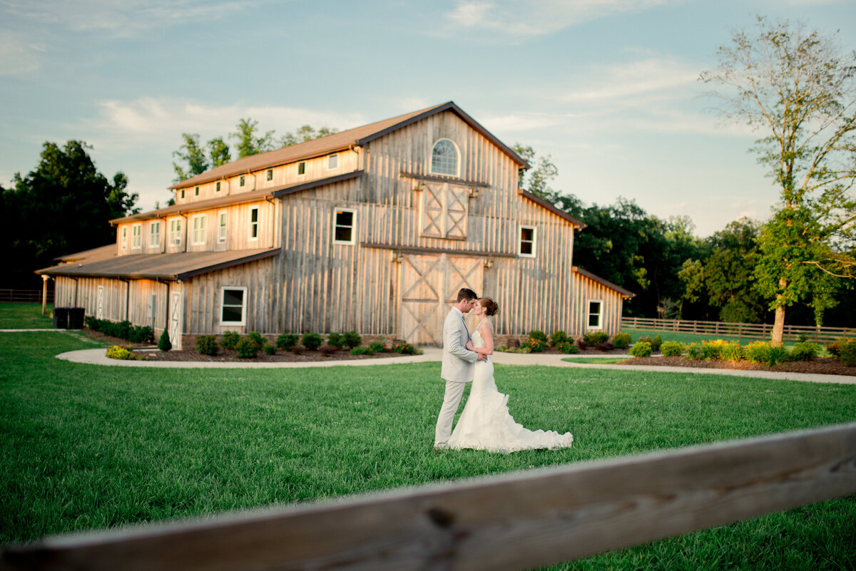 Couple taking picture out on lawn in front of barn