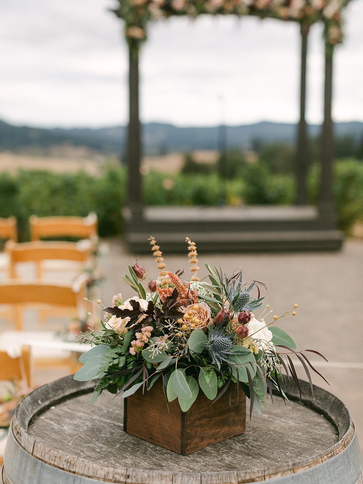 Wedding floral arrangement atop a wine barrel.