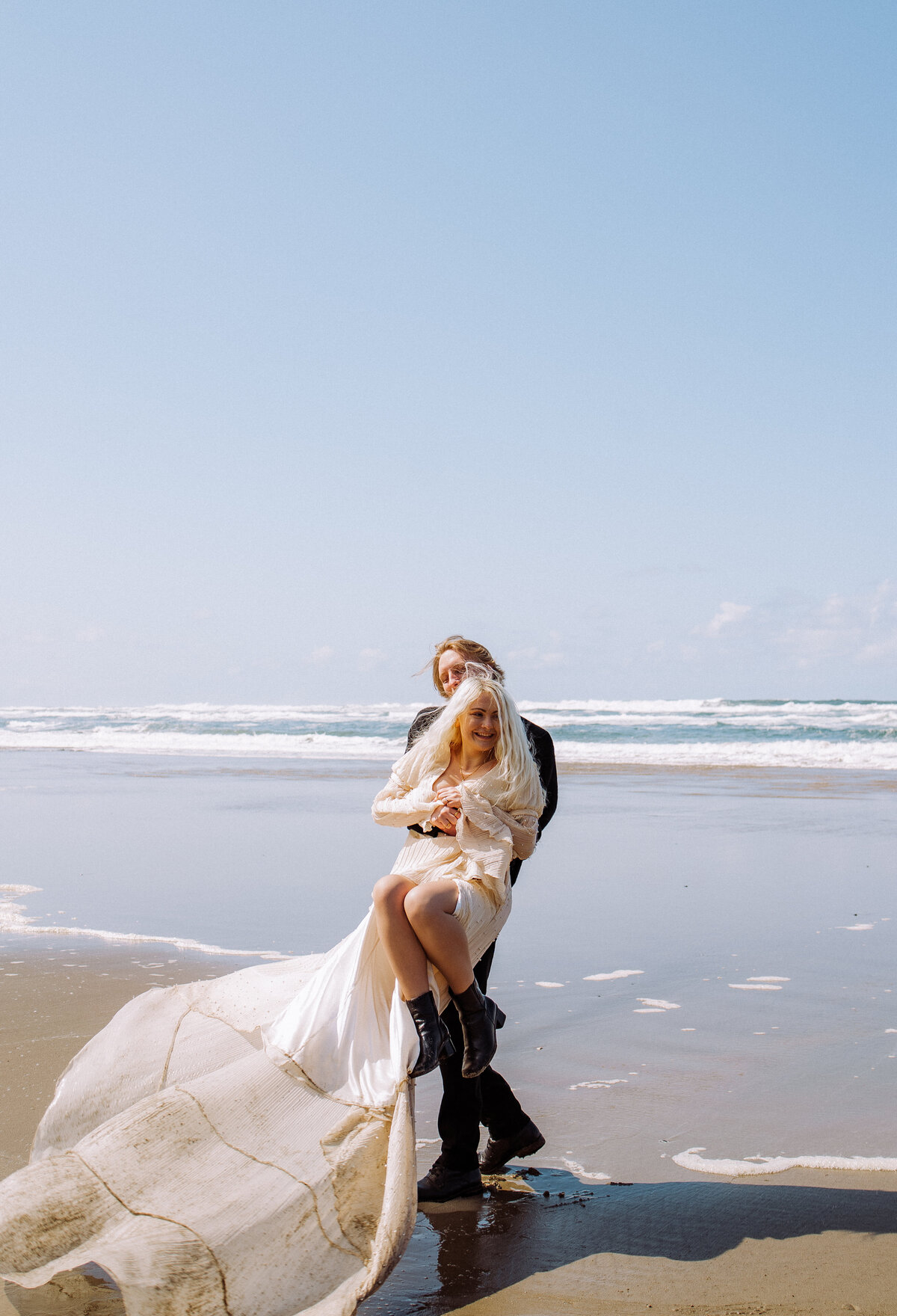 groom carrying happy bride on beach destination wedding
