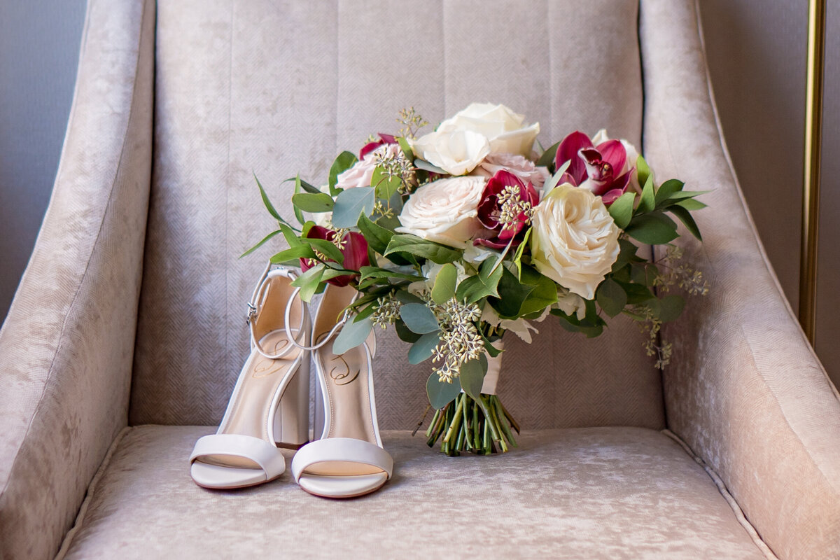 brides shoes and flower bouquet sitting on a chair