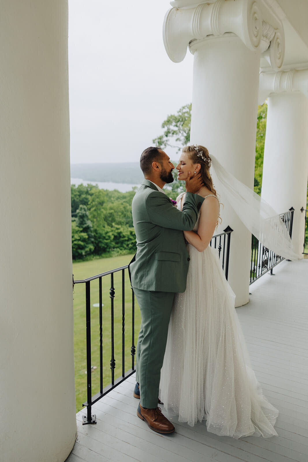 Bride and groom kssing on balcony at The Mansion at Keuka Lake, NY