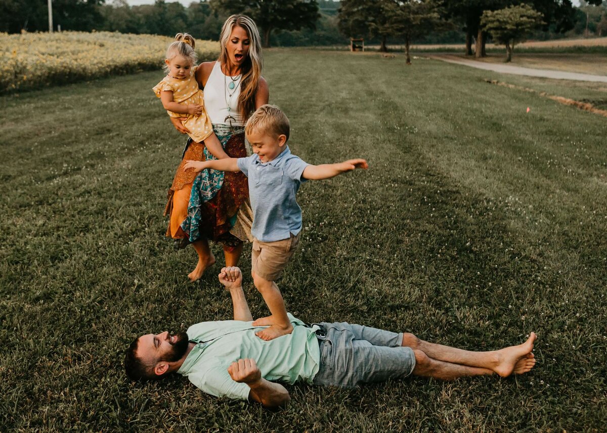 A Pittsburgh family photographer capturing a family playing in a field with their children.