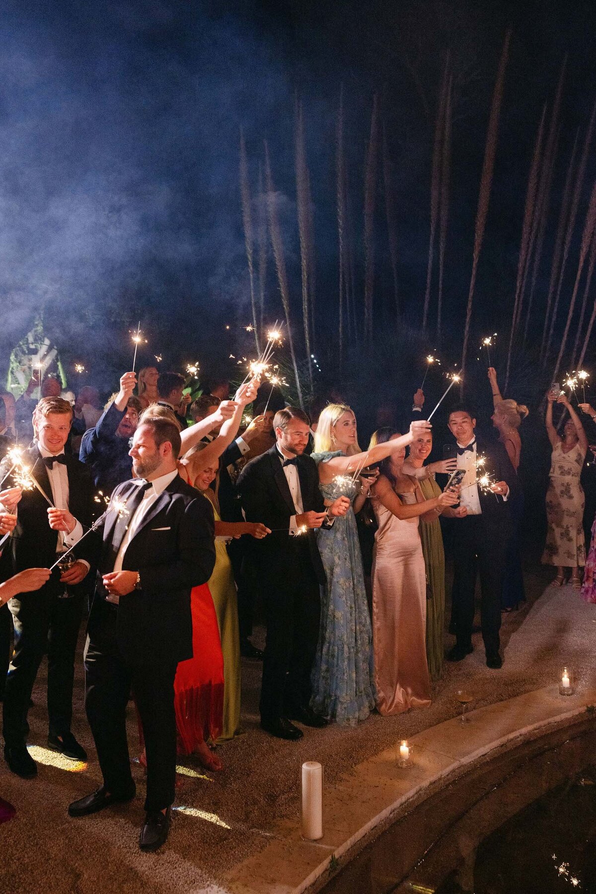 Night shot of guests holding sparklers for the couple's first dance.