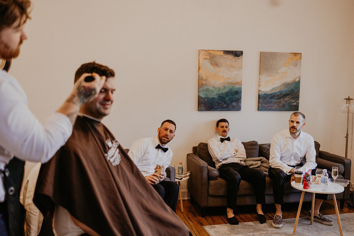 groom and his barber getting ready for his wedding