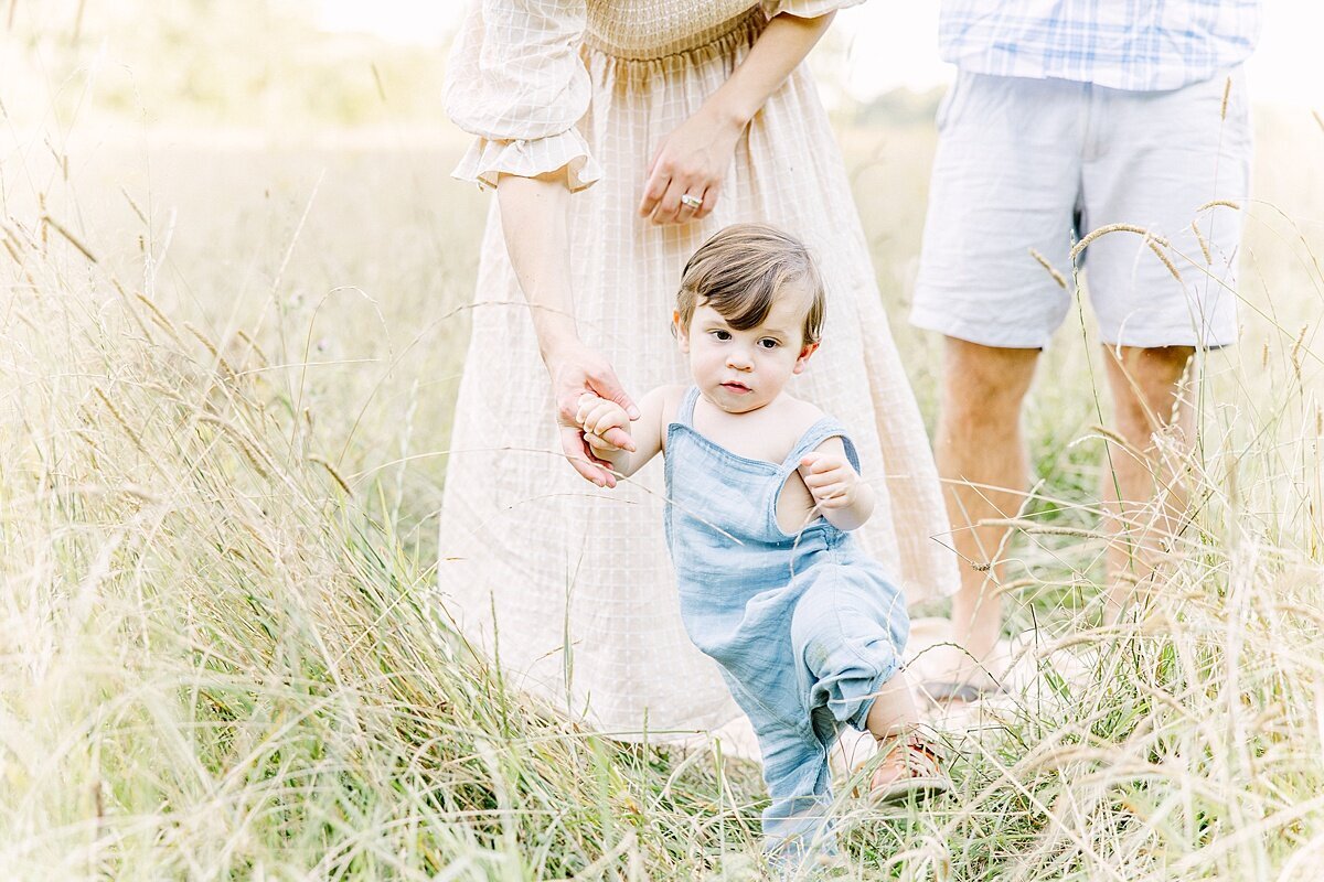 son holds moms hand duirng summer  family photo session with Sara Sniderman Photography in Natick Massachusetts