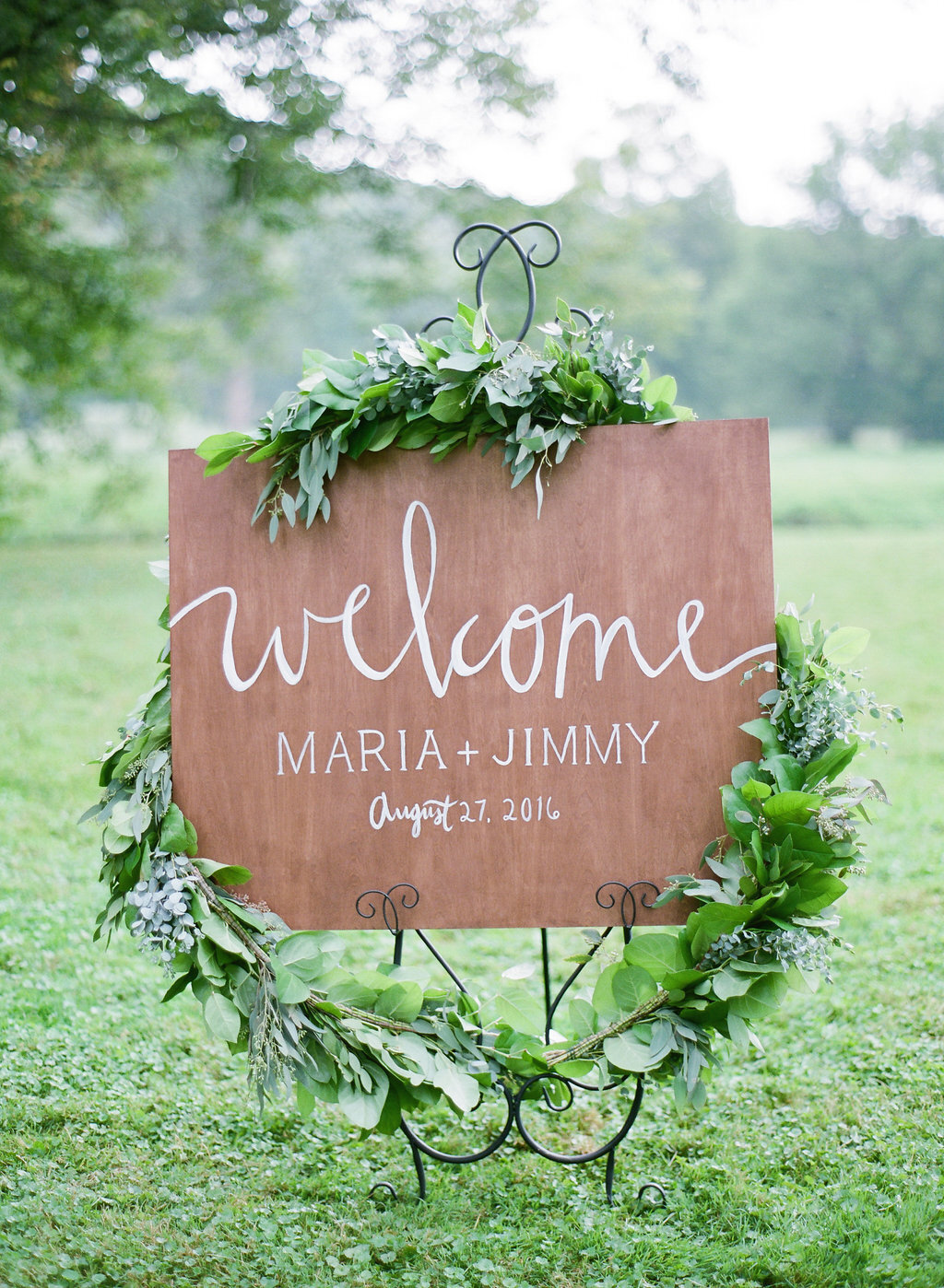 Beautiful welcome sign for a green and white wedding at a private estate