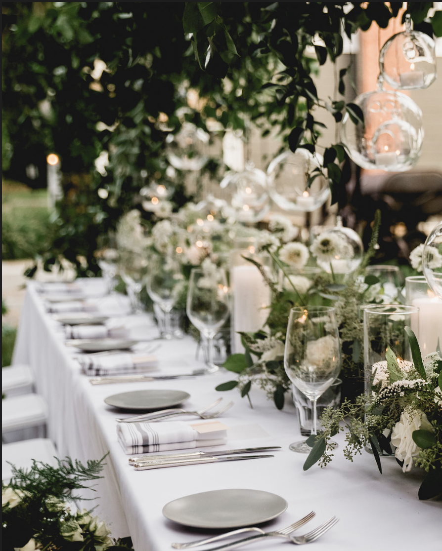 Chic al fresco event setup with detailed white place settings and green floral accents at Hasbrouck House in Stone Ridge, NY.
