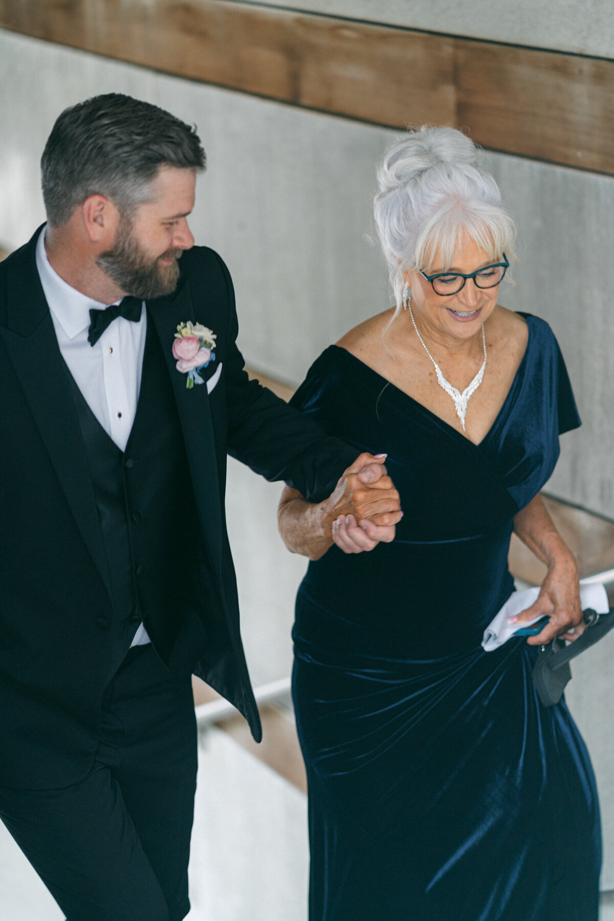 A wedding photo of the groom walking with his mother at Crystal Bridges Museum of American Art in Arkansas
