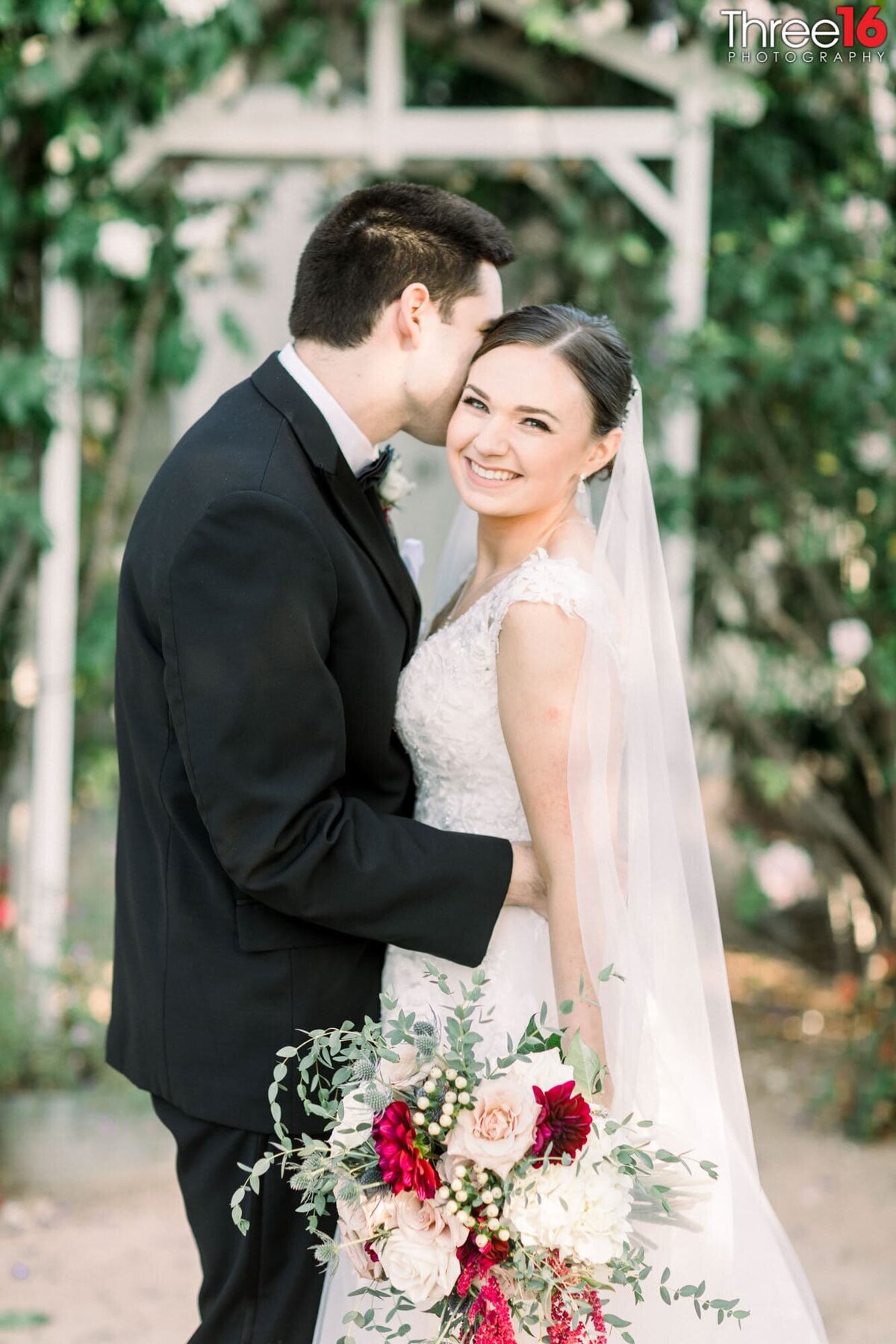 Groom whispers into his Bride's ear giving her a large smile