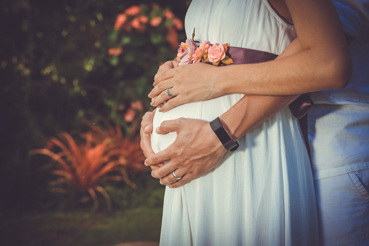 Maternity shot of parents' hands on pregnant belly. Photo by Ross Photography, Trinidad, W.I..