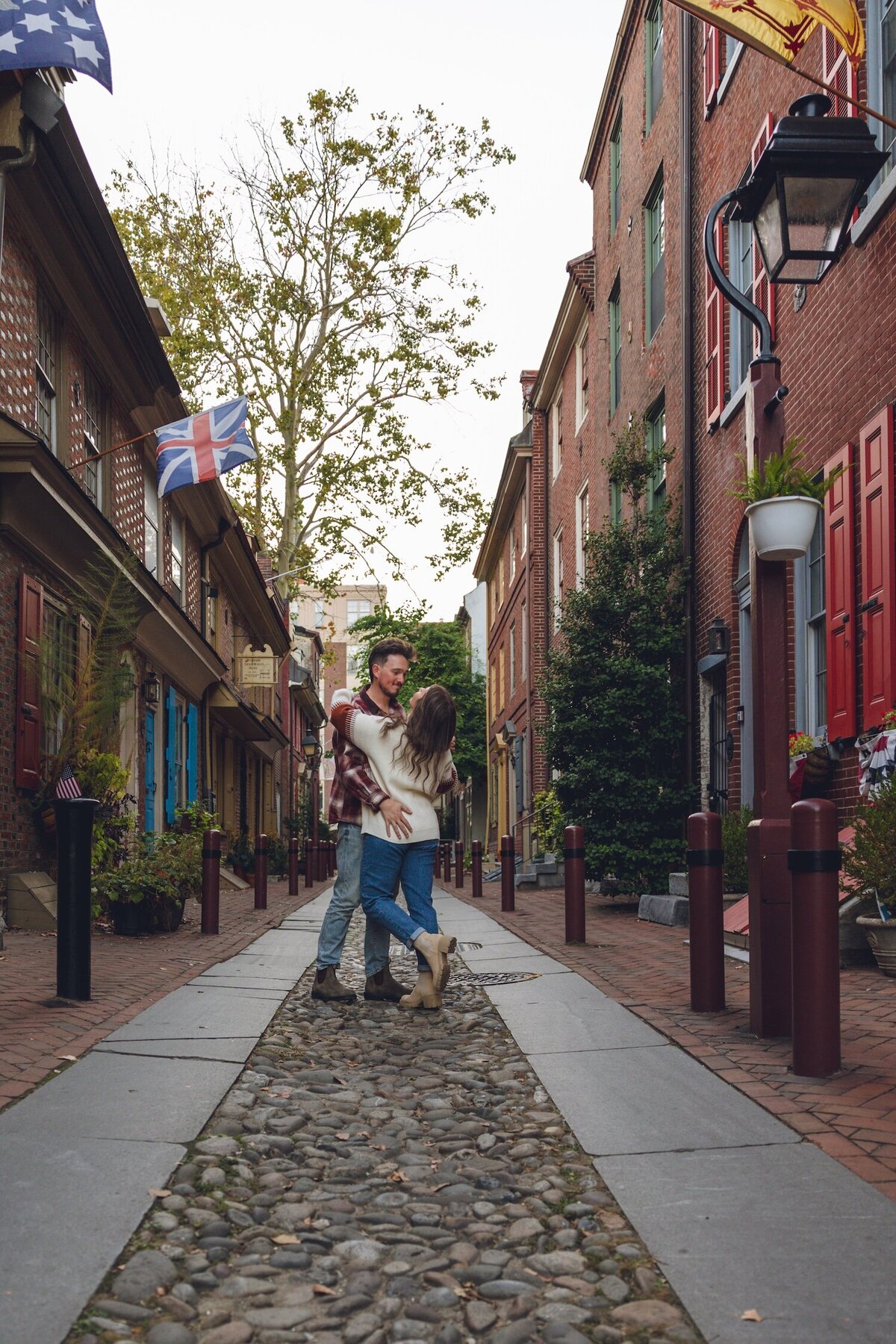Laughing couple sharing a sweet moment by cobblestone street.
