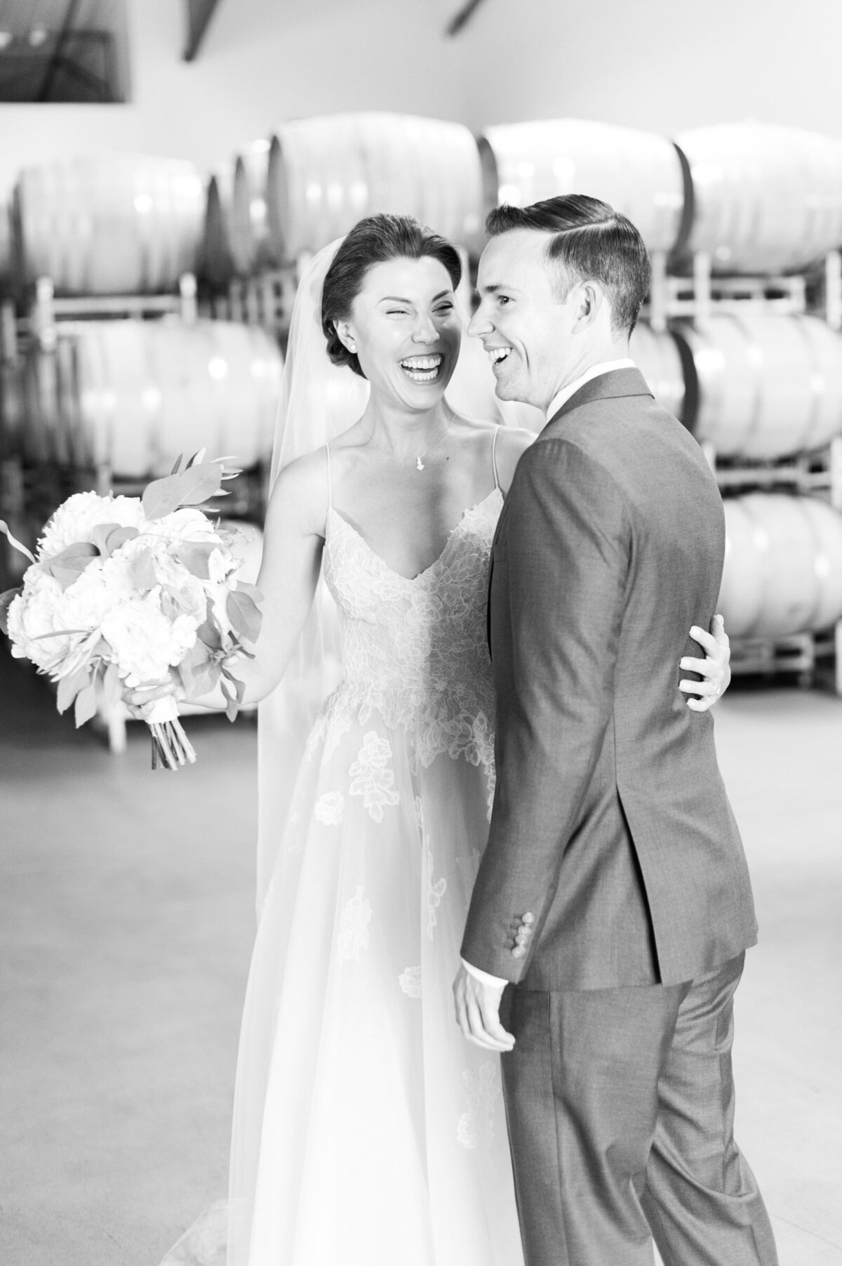 bride and groom laughing together in barrel room at ponzi winery