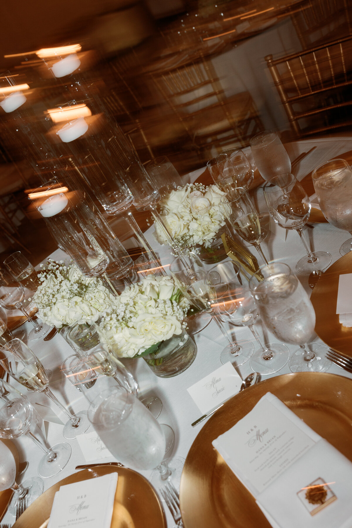 Romantic reception tablescape with white florals and candles by Philadelphia wedding photographer.