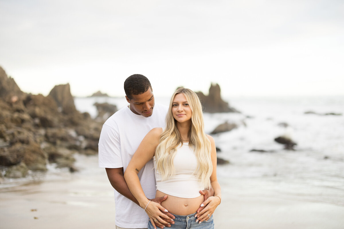 maternity photo on the beach with cliffs and rocks
