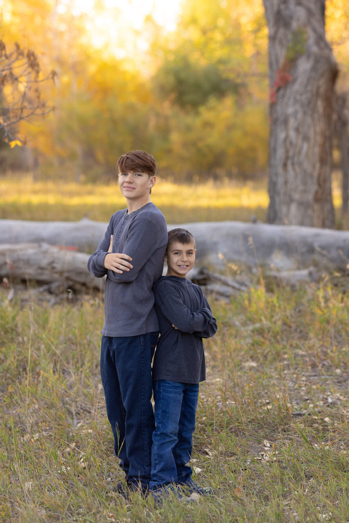 two brothers standing back to back in a field